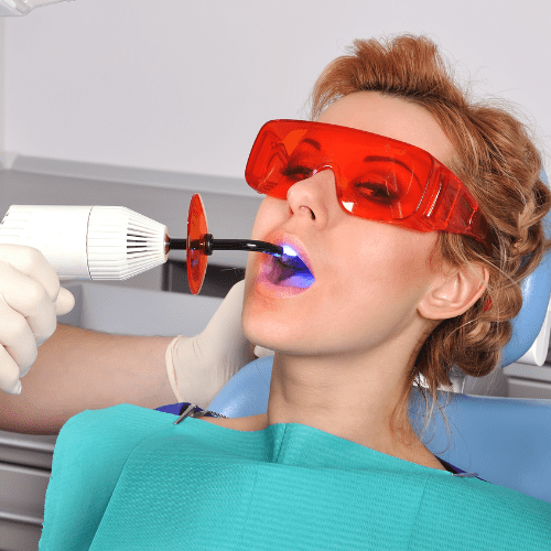 Woman receiving tooth filling treatment in dental chair